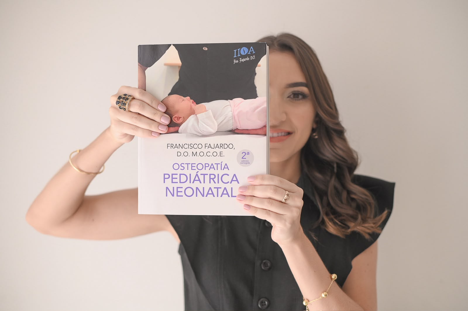 Isabela Trovatti com livro de osteopatia pediátrica neonatal